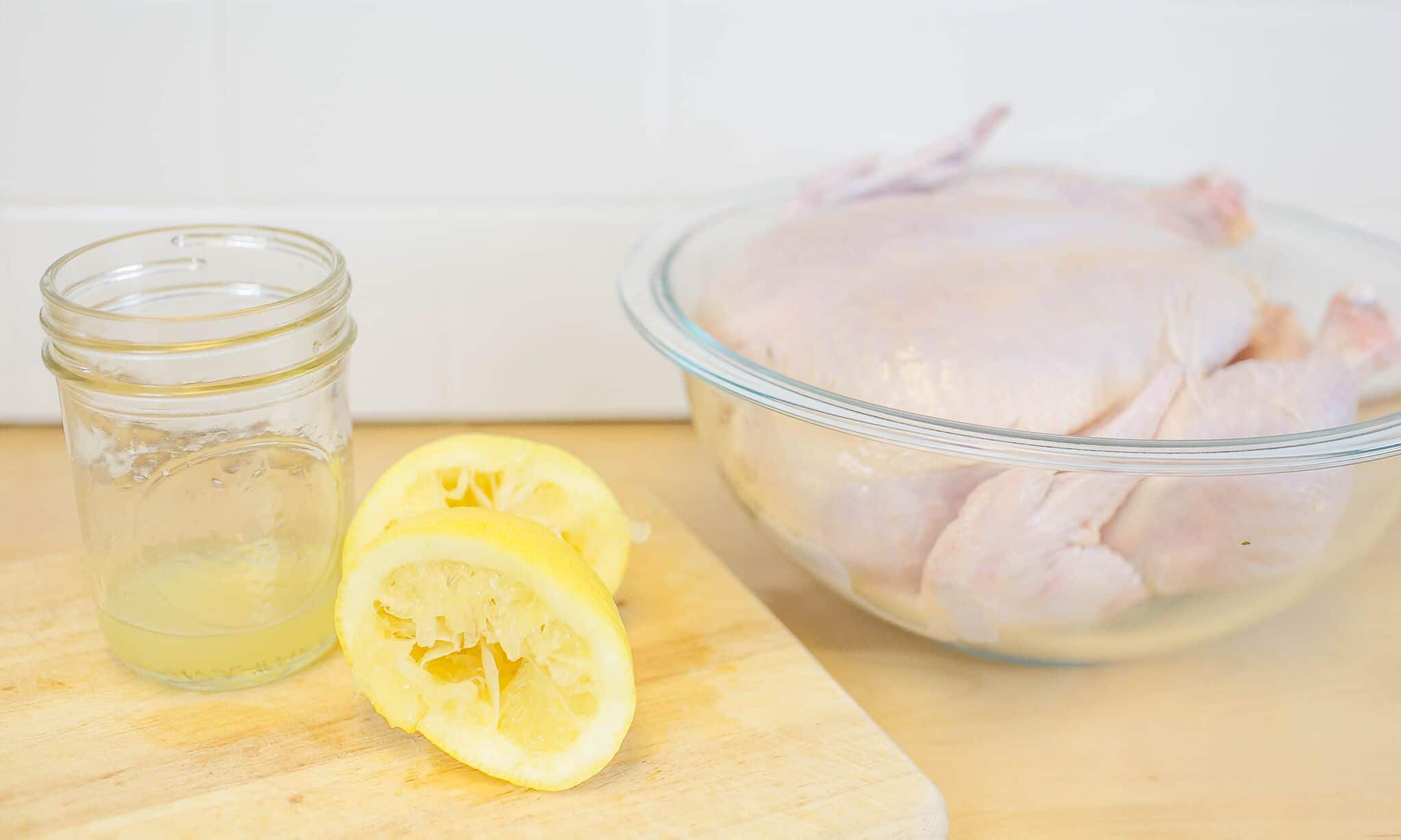 Squeeze the juice of half a lemon and set aside near whole chicken in bowl. 