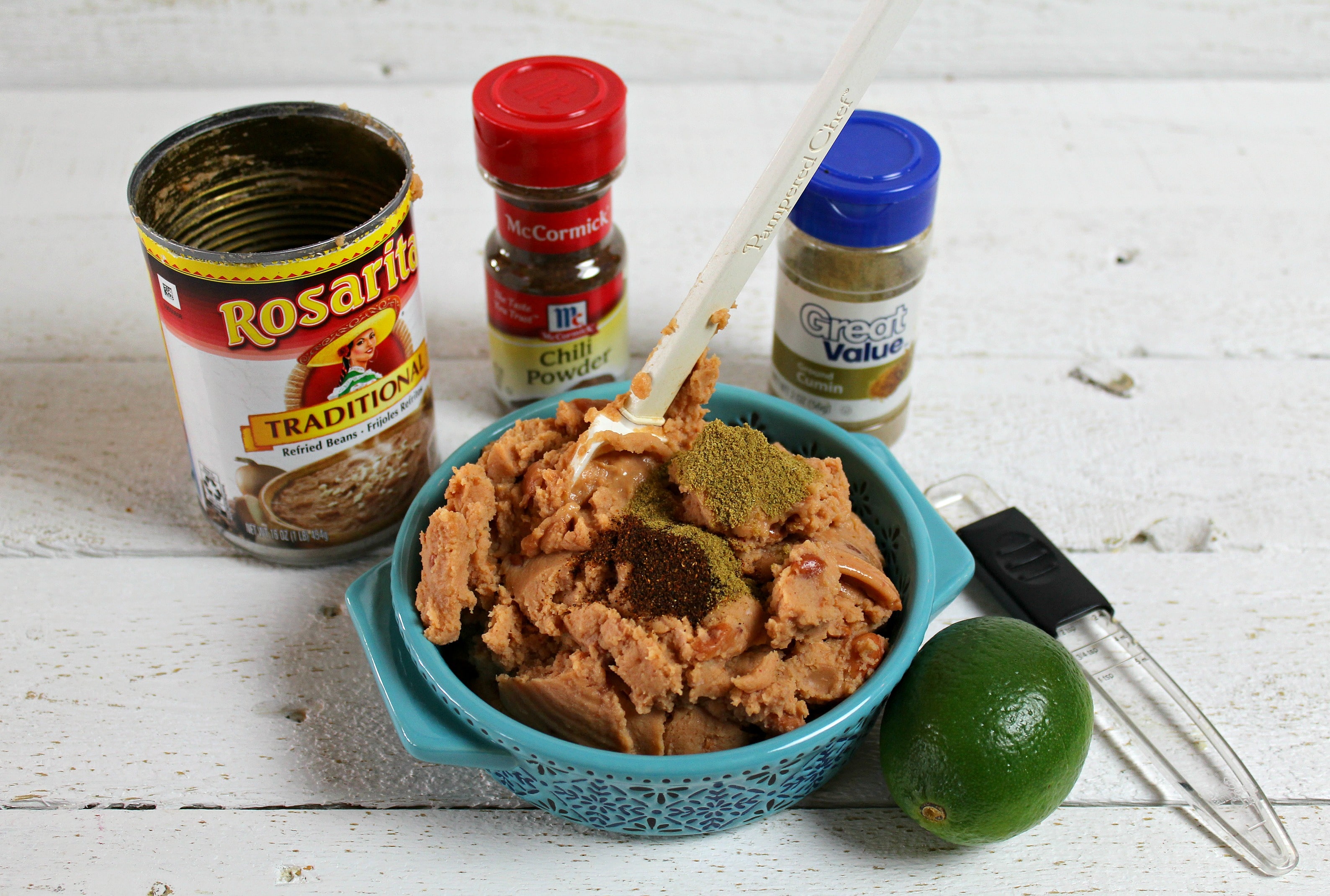 In a small bowl mash the refried beans with lime, chili powder and cumin. 