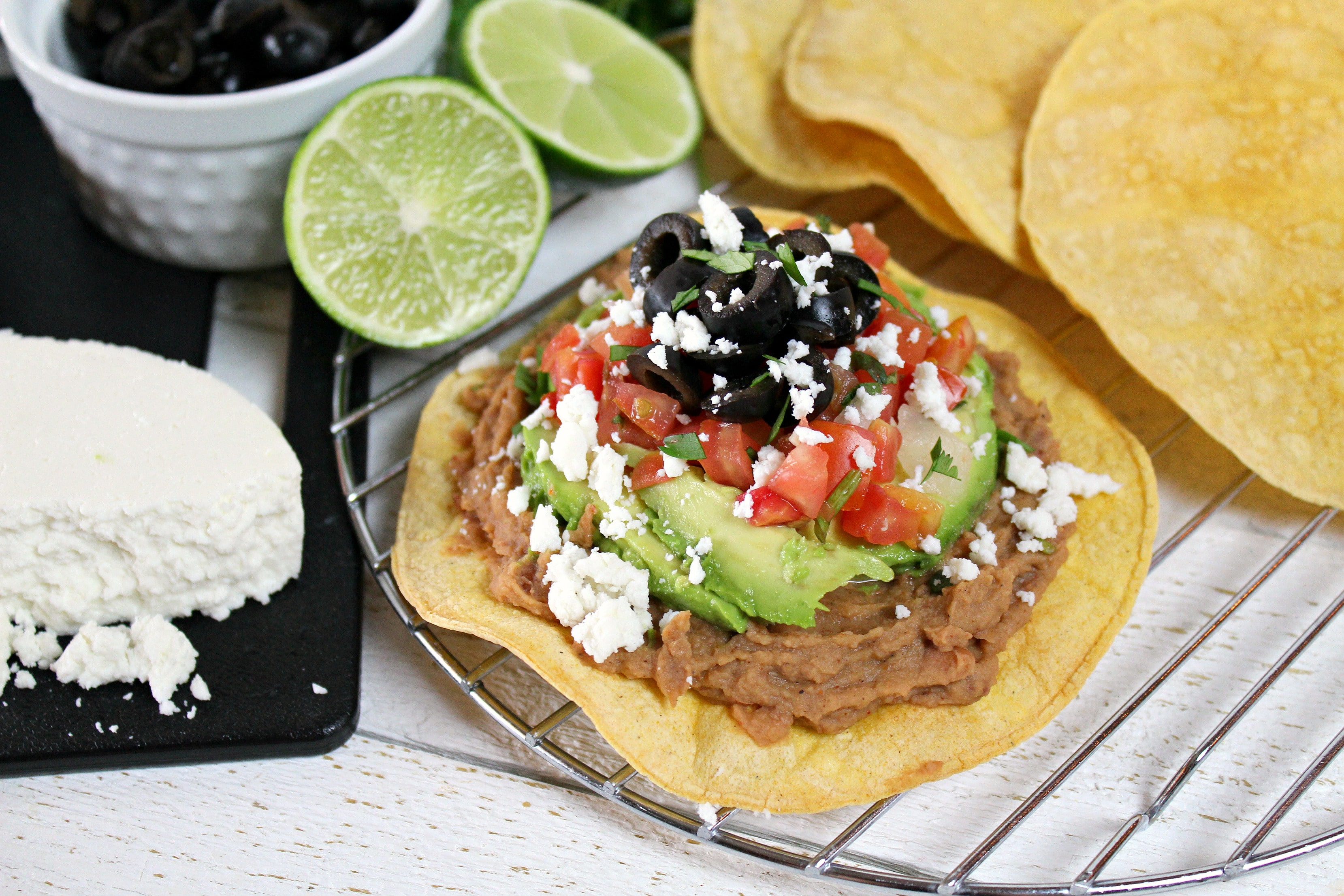 Assemble the easy, healthy vegetarian tostadas by topping them with the beans, vegetables and queso fresco. 