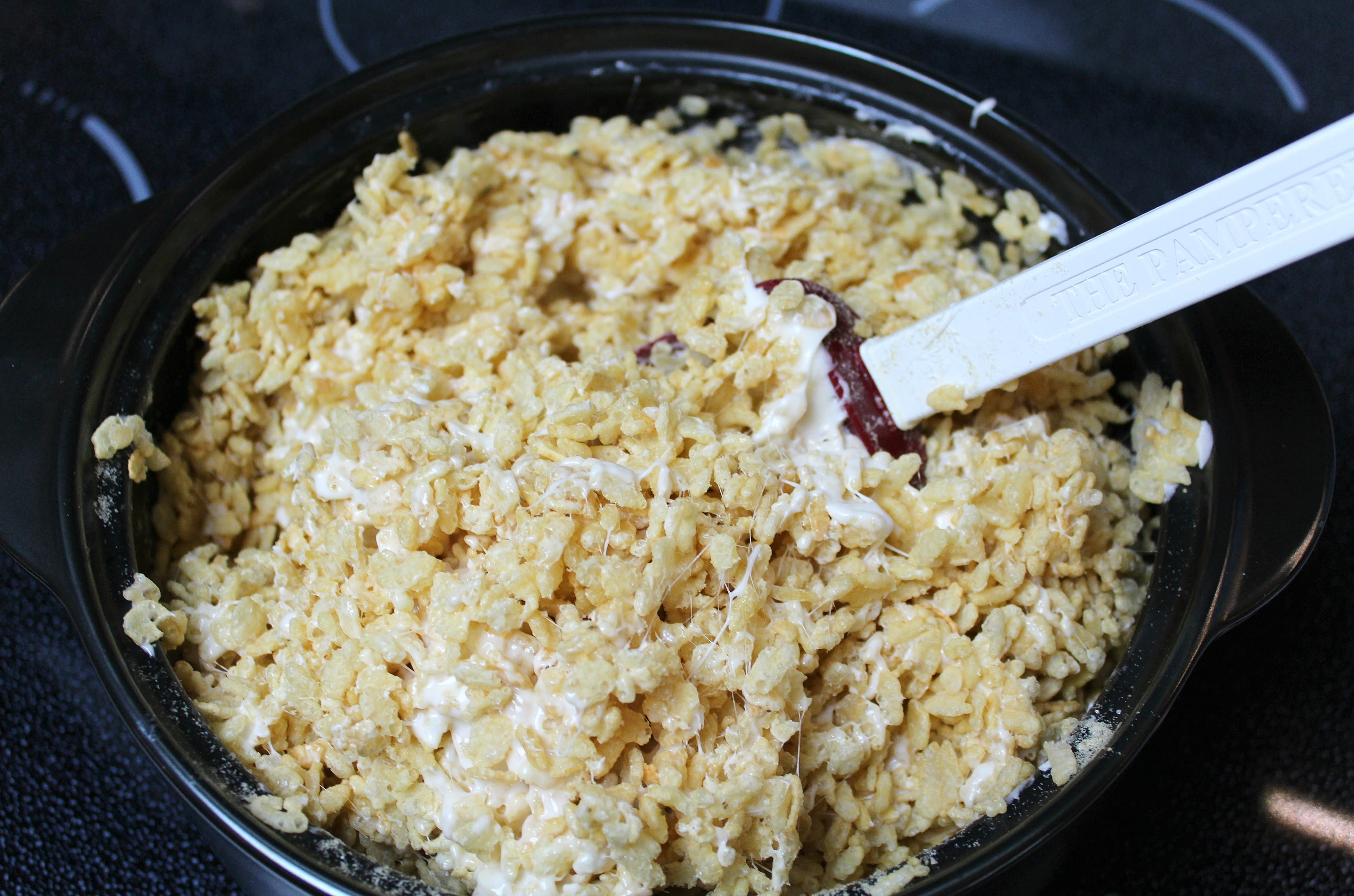 Stir the marshmallow into the rice crispies until they're thoroughly coated. 