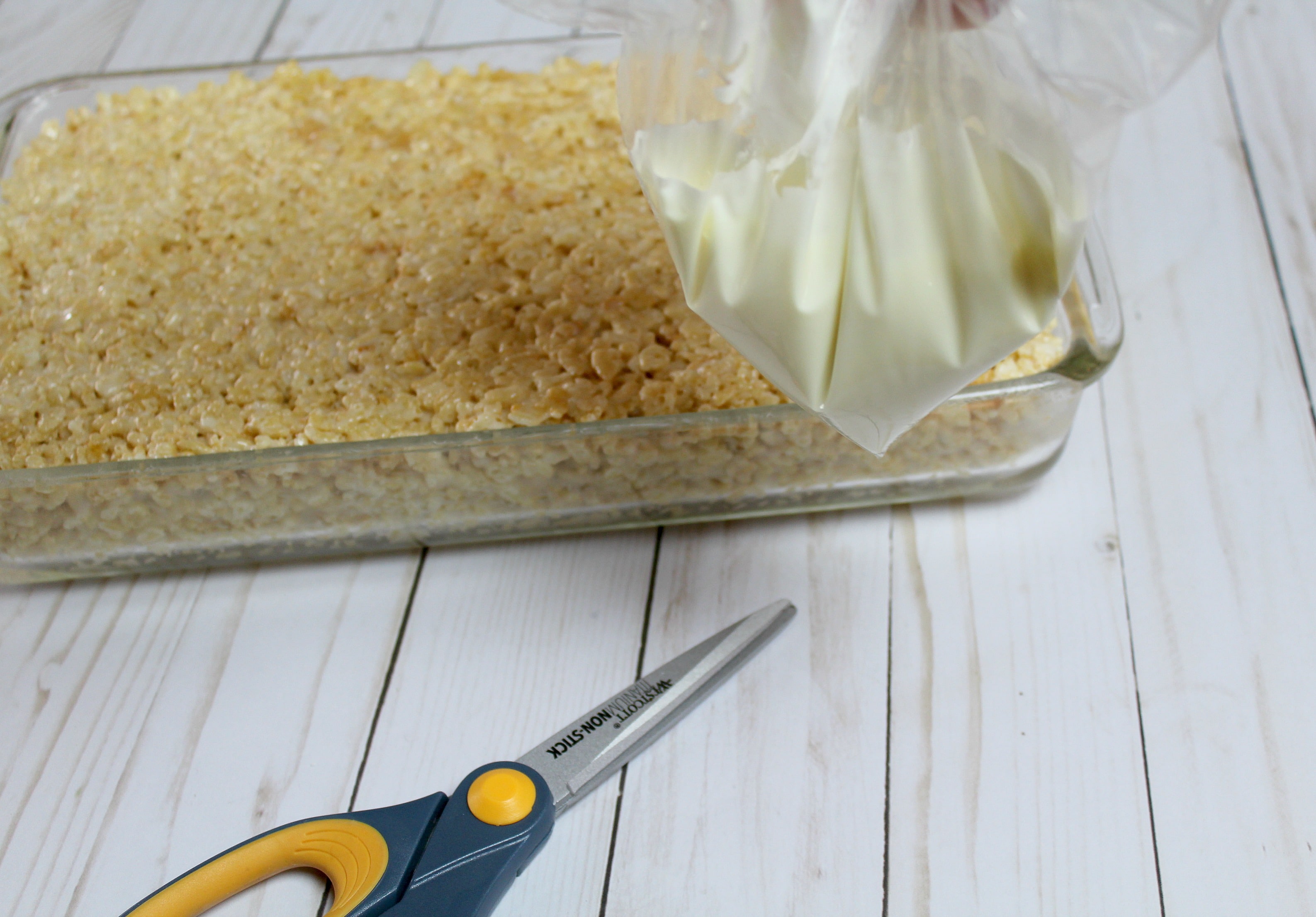 Snip the end of the bag off using scissors to create an icing bag for your rice crispy treats. 