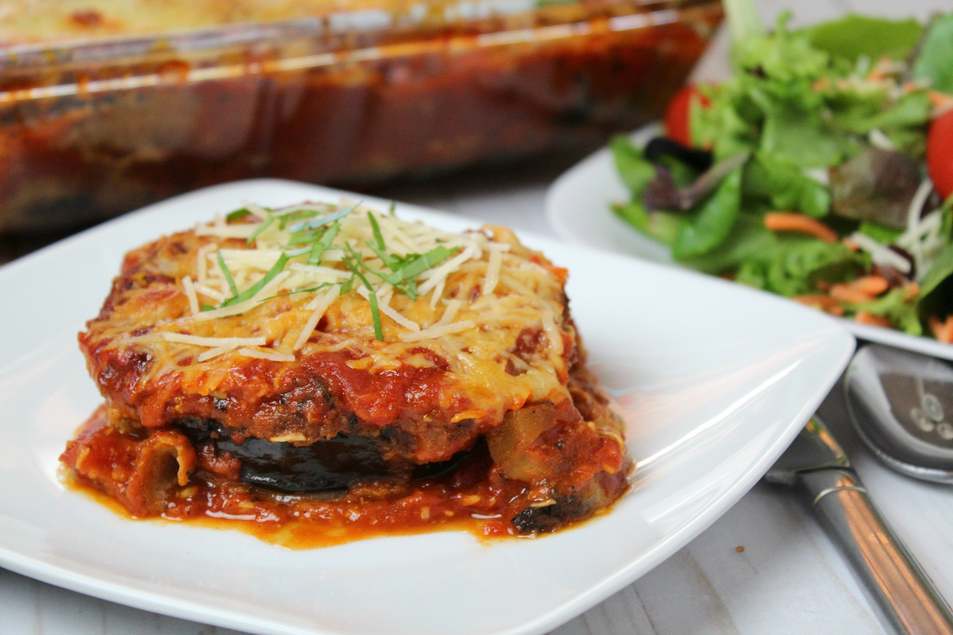 Serve finished eggplant Parmesan in plate with garnish. 