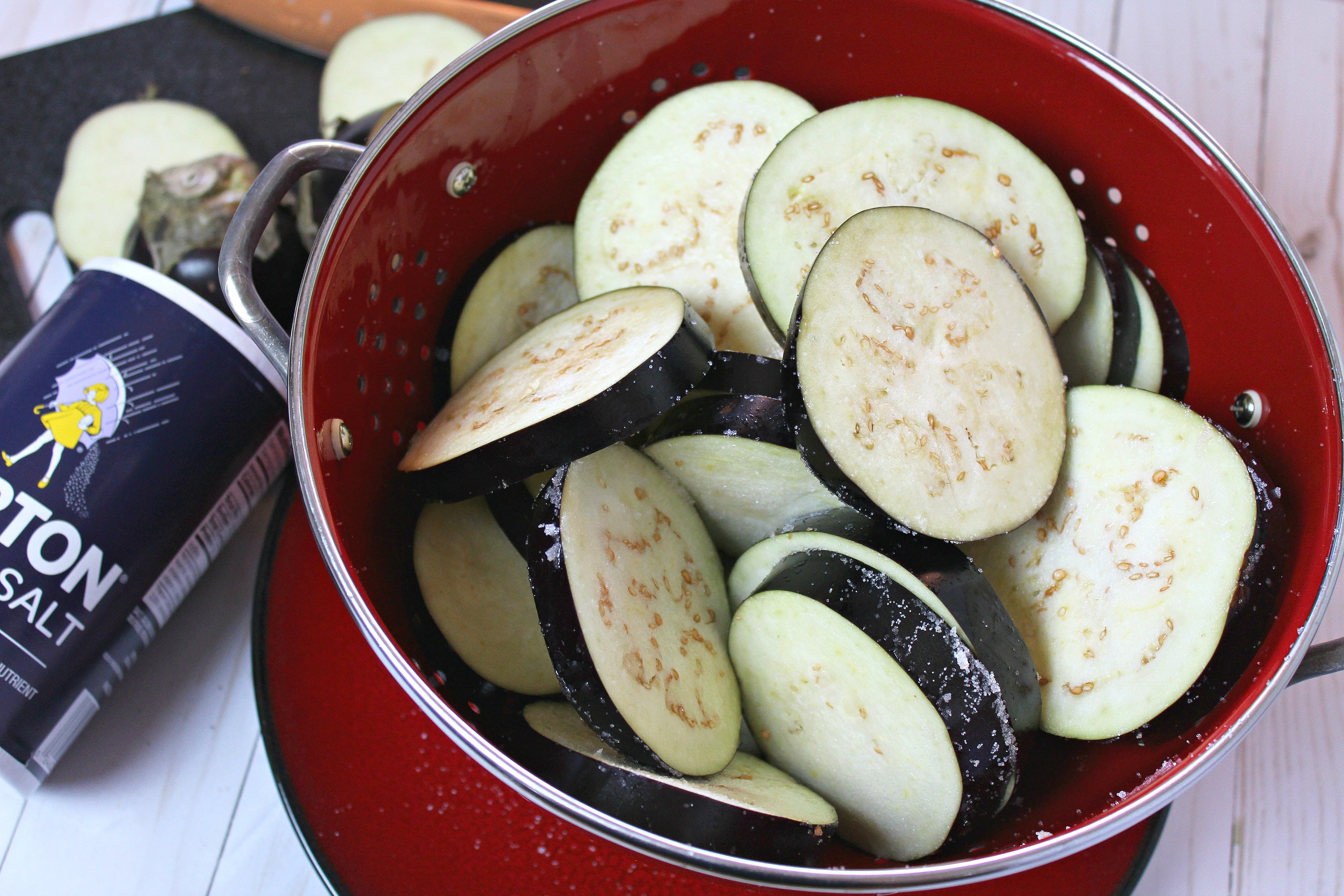 Place eggplant in a colander and sprinkle generously with salt.