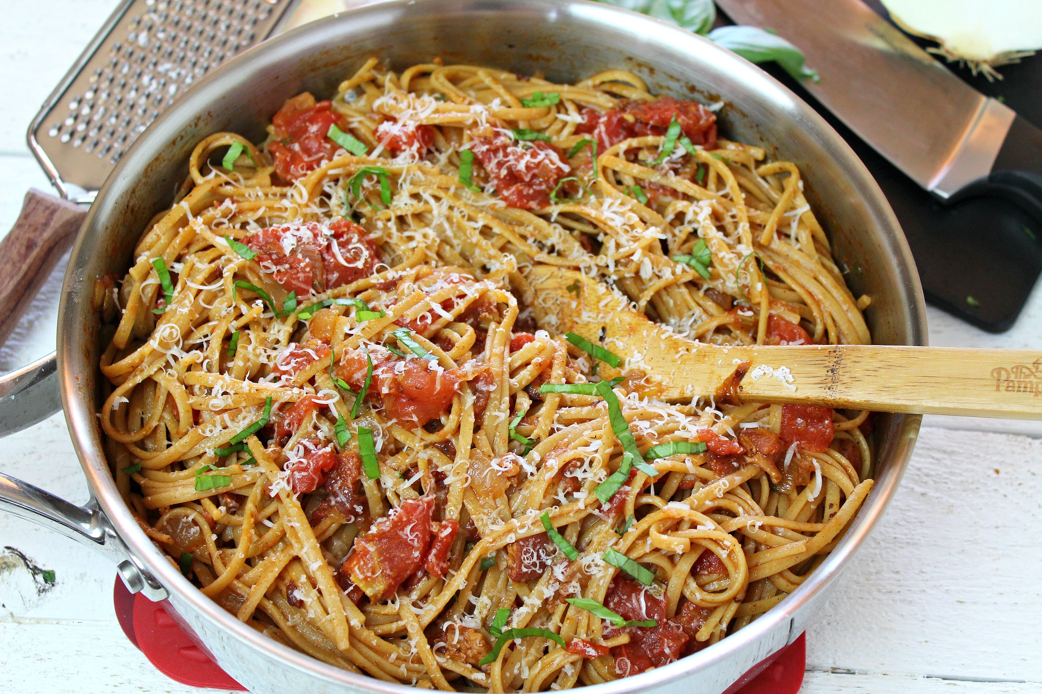 Serve linguine amatriciana topped with parmesan cheese and some chopped basil for a delicious homemade dinner