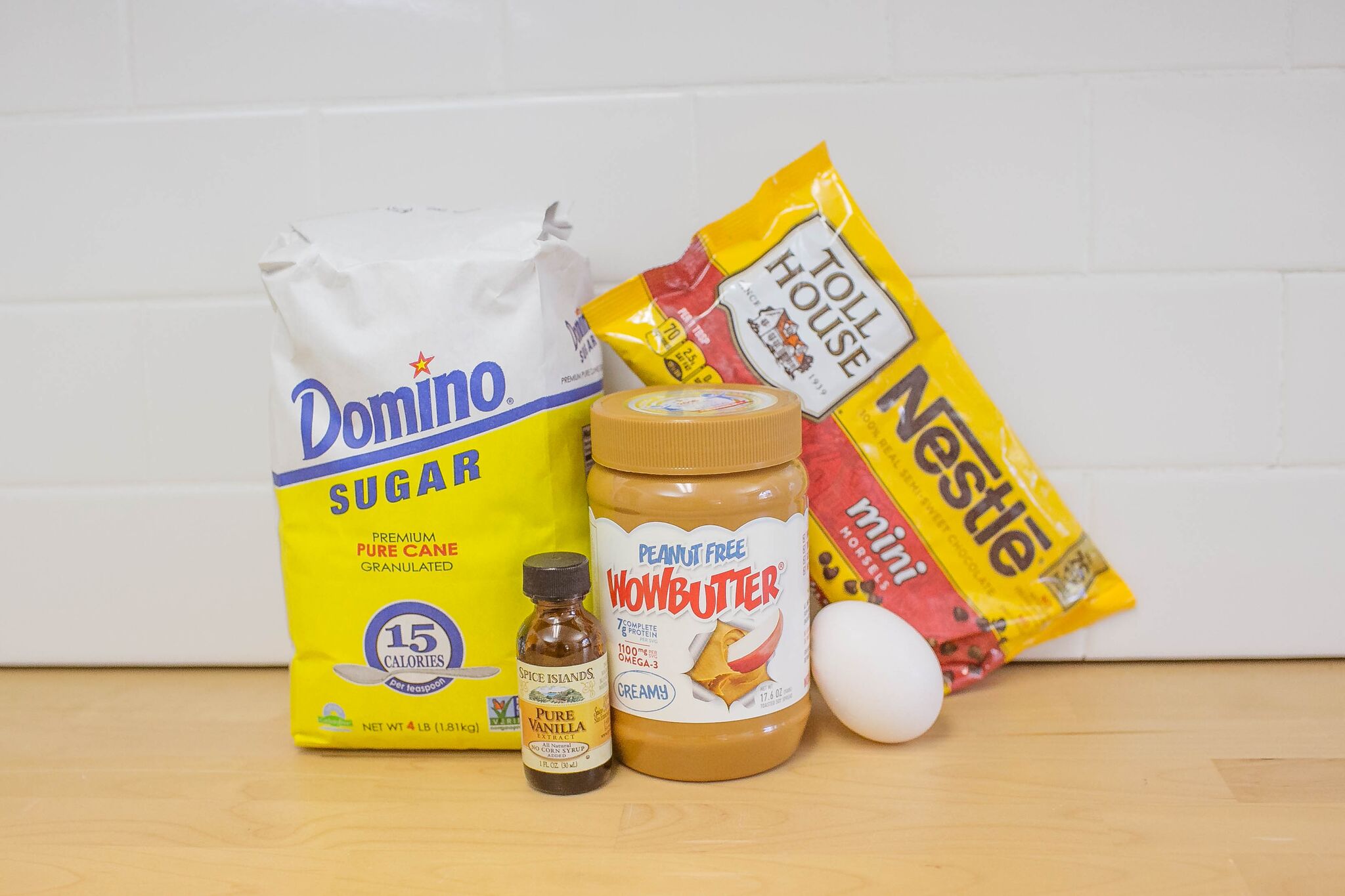 Assemble your ingredients for the un-peanut butter bookies: peanut free Wowbutter, vanilla, sugar, one egg and mini chocolate morsels. 