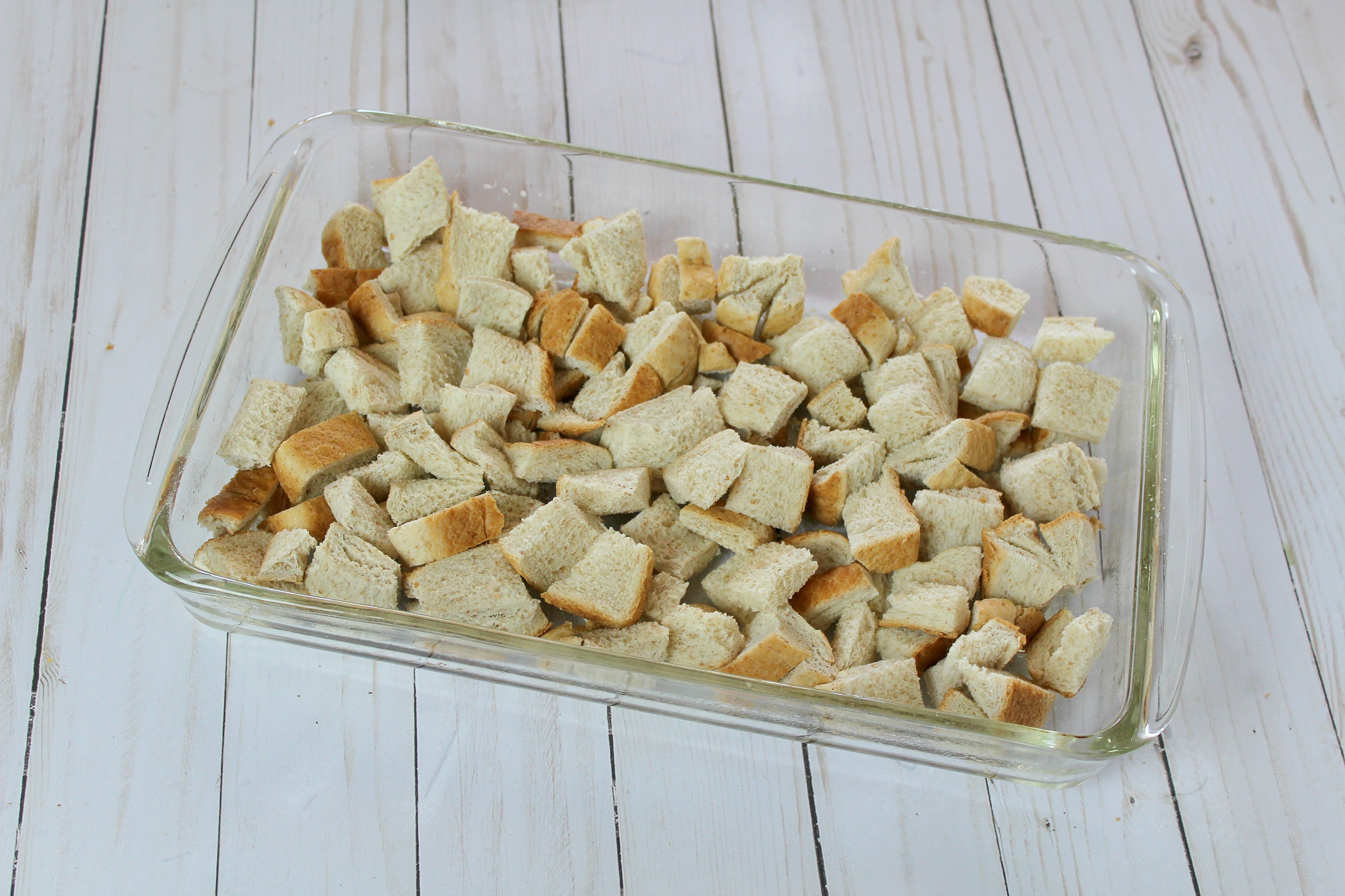 Layer chopped bread in a greased baking dish.