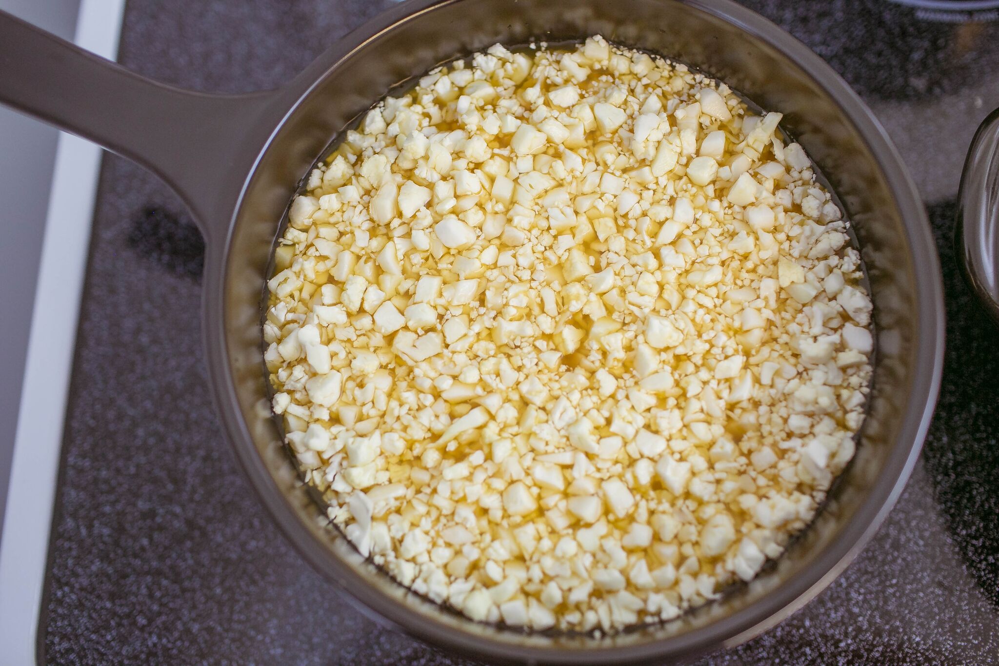 In a large pot add vegetable stock and then add "riced" cauliflower. 