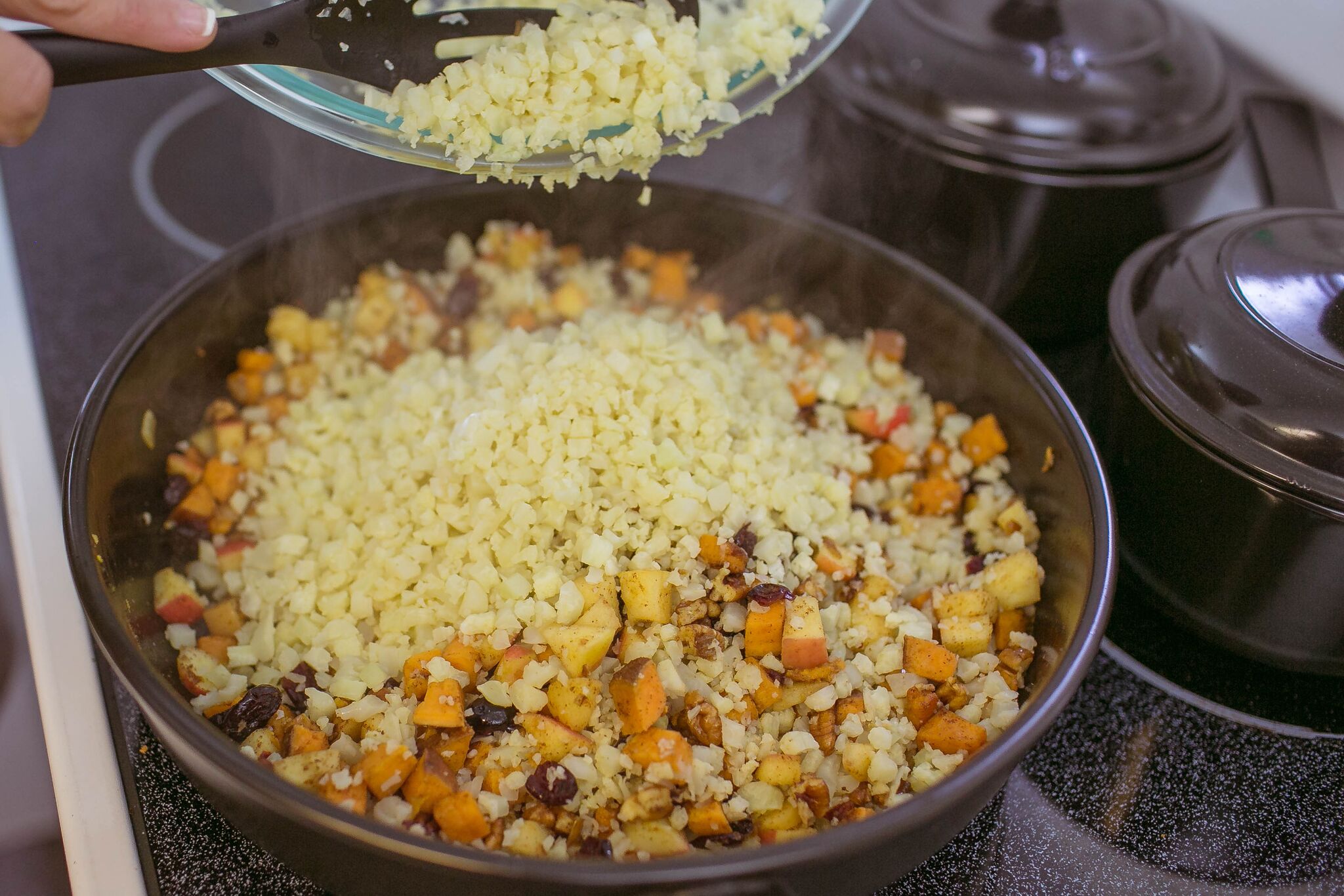 Add "riced" cauliflower to sweet potato mixture in pan. 