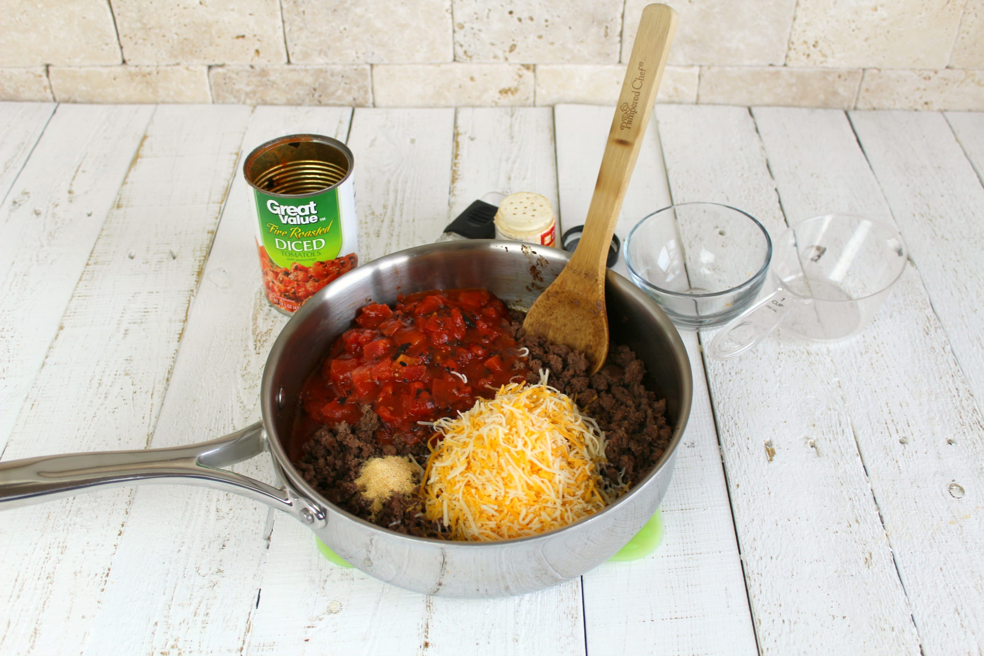 Brown ground meat on stove top and stir in fire roasted tomatoes, garlic powder, salt and cheese.