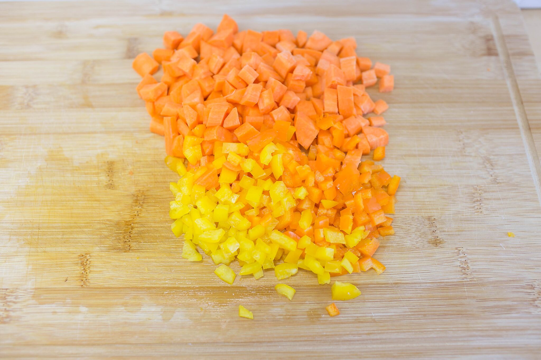 Dice carrots and peppers into bite sized pieces