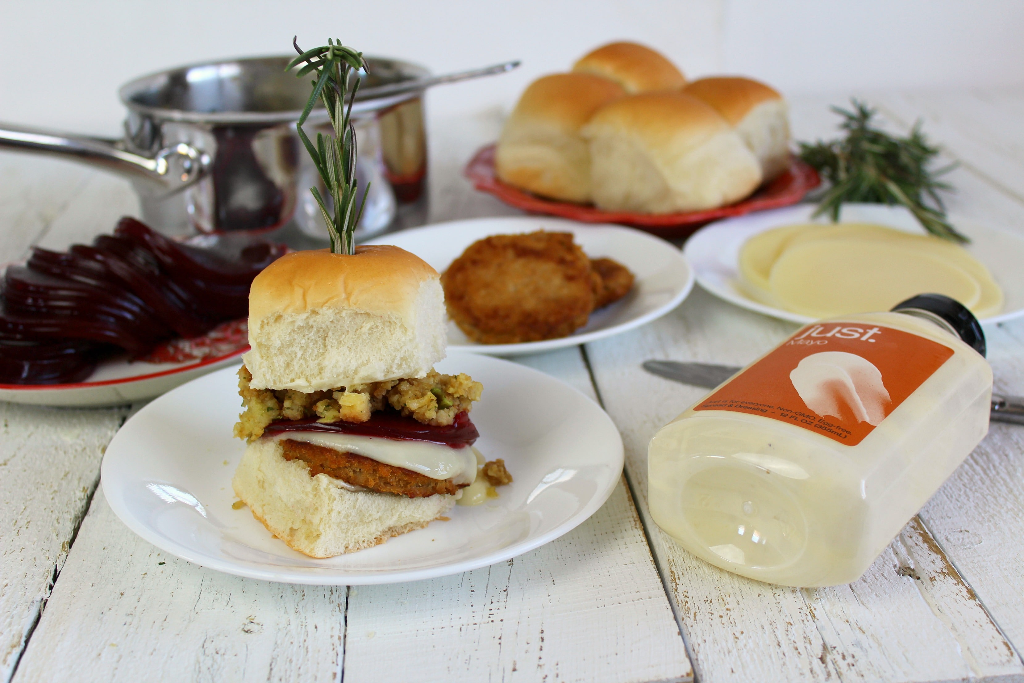 Assemble burgers by cutting dinner rolls in half then adding each ingredient step by step. 