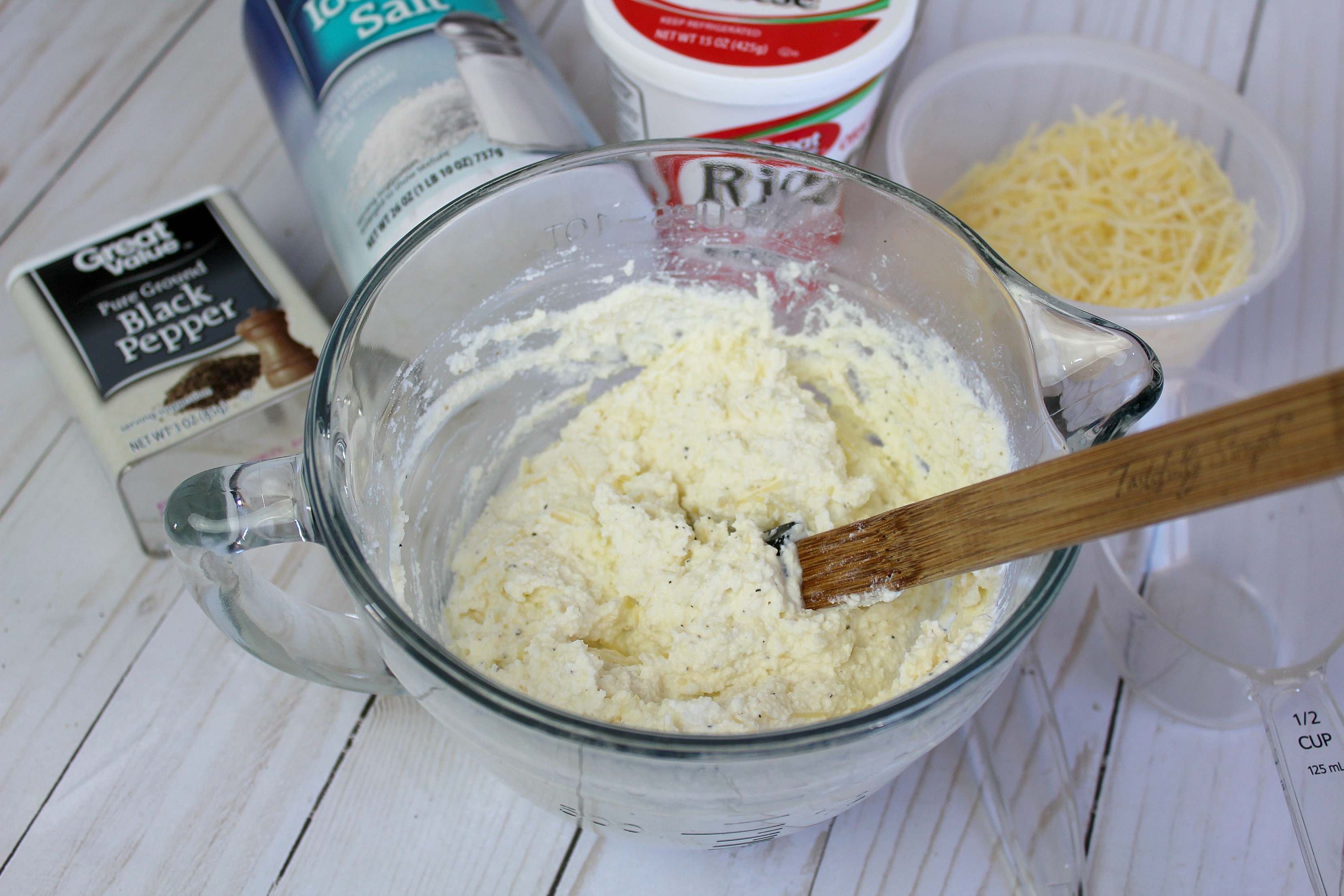 Mix the parmesan and ricotta cheese together in a bowl, then add salt and pepper. 