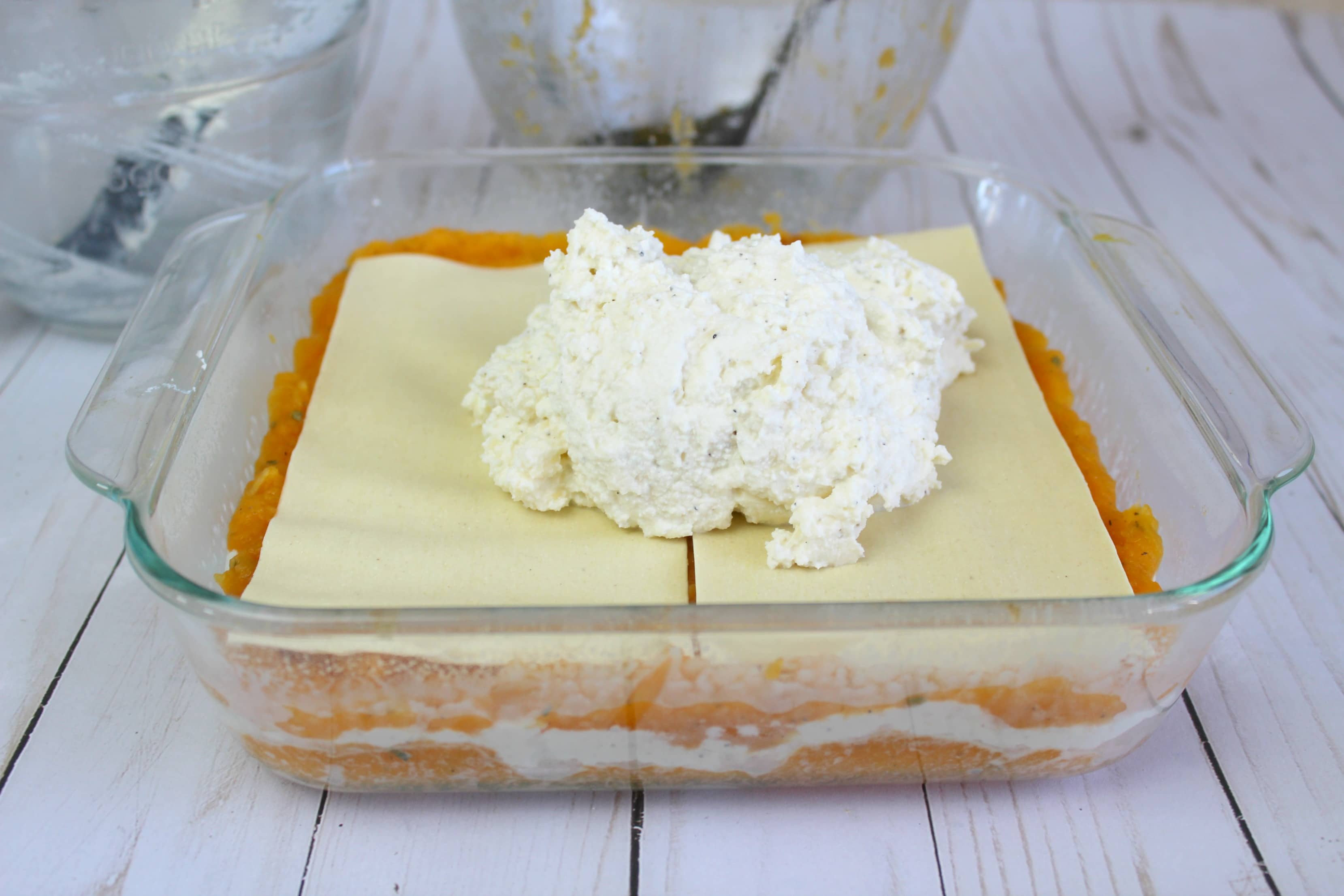 Assemble the lasagna, alternating between pasta sheets, squash mixture, and cheese spread. 