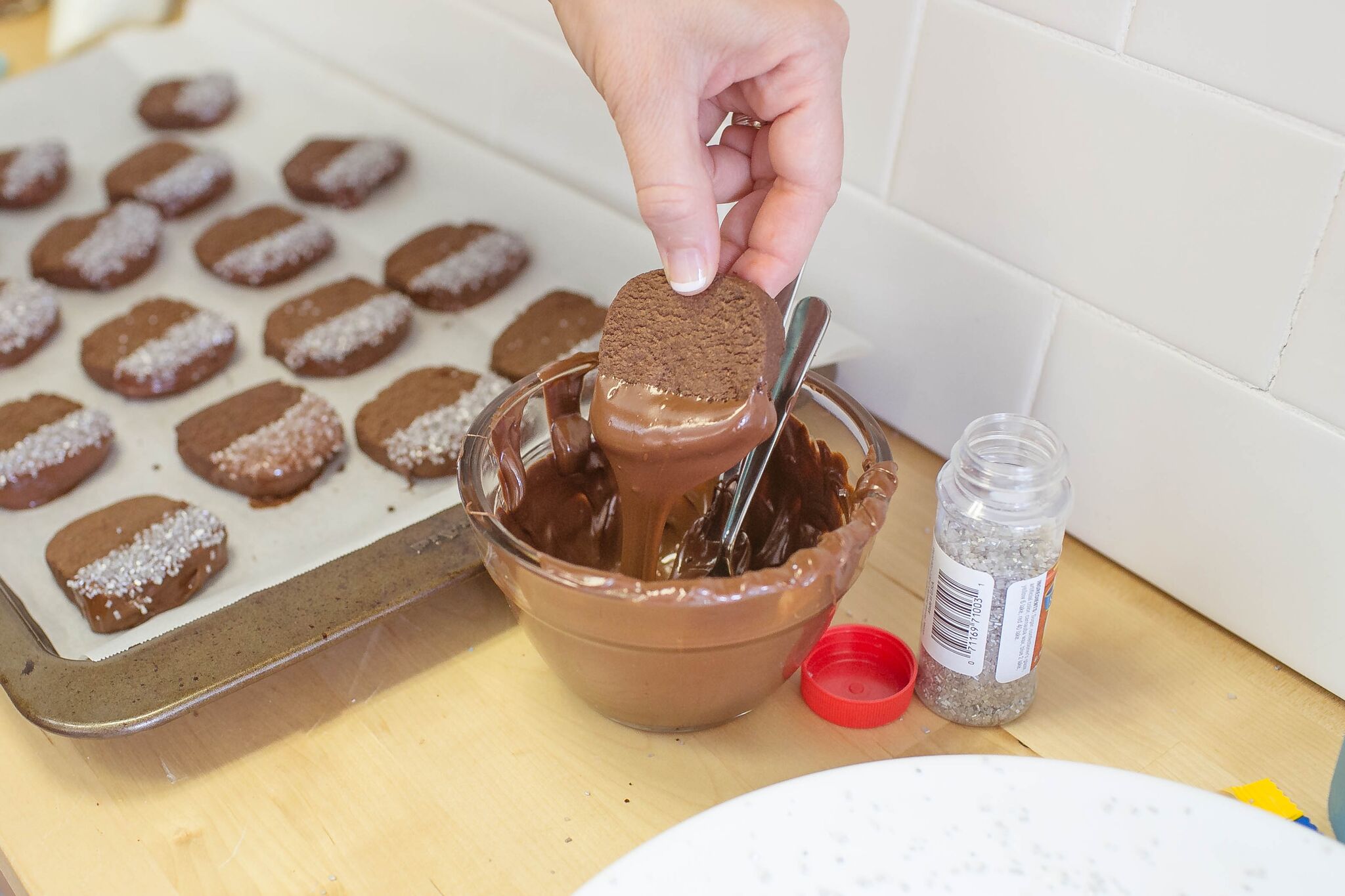 Dip cooled cookies into melted chocolate and add sugar. 