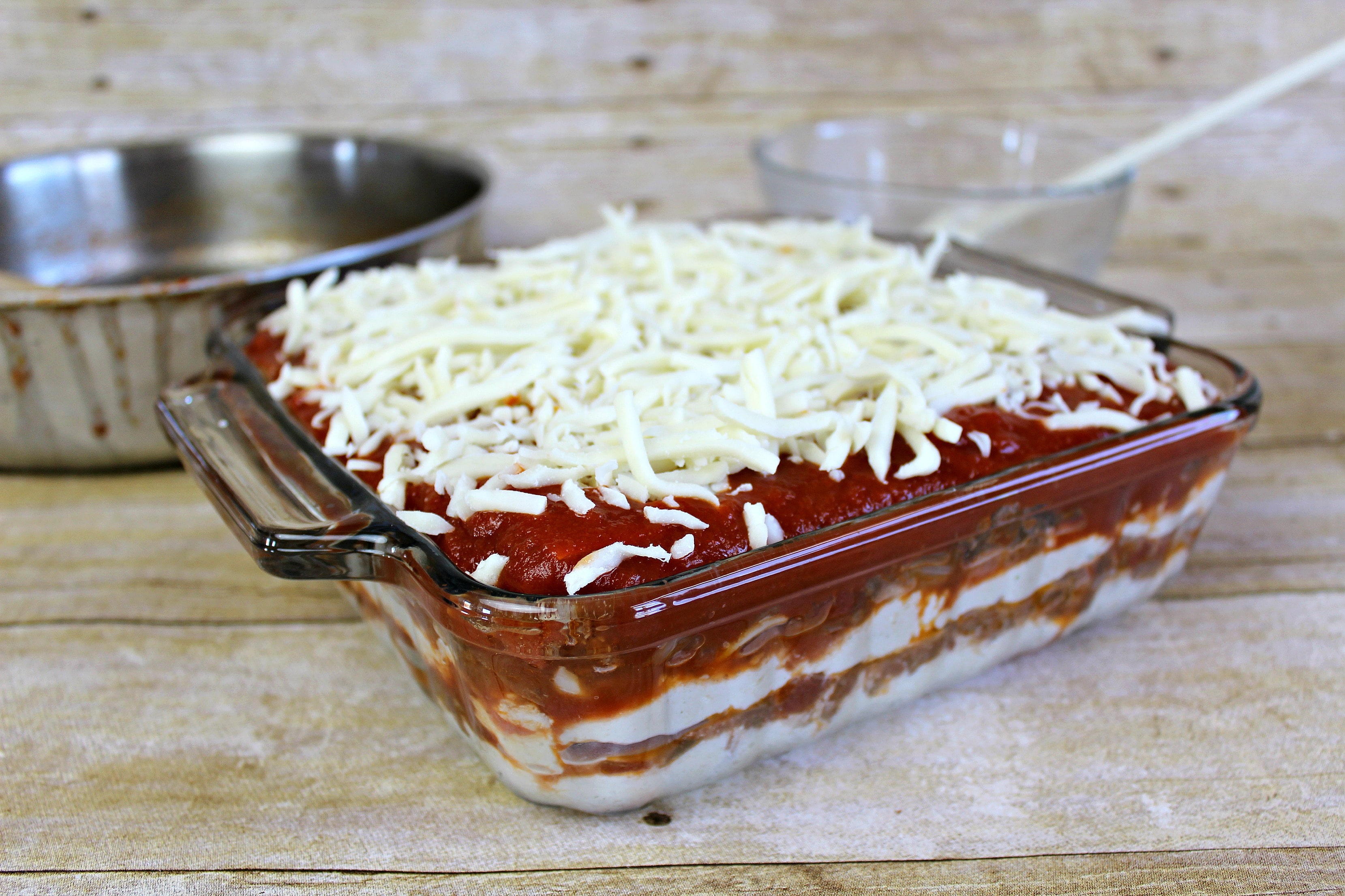 Layer the noodles, lasagna sauce and cheese in a shallow glass baking dish. 