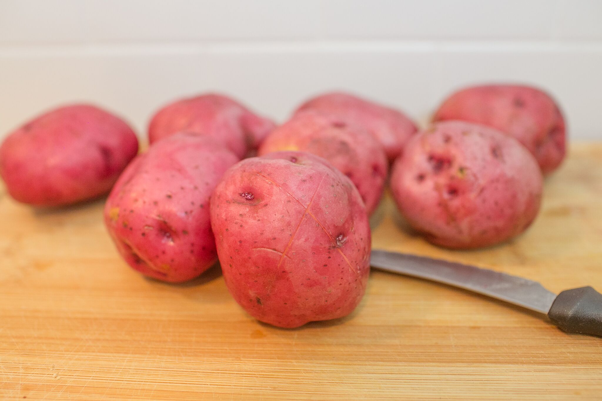 Wash the potatoes well and cut a small X into each one.