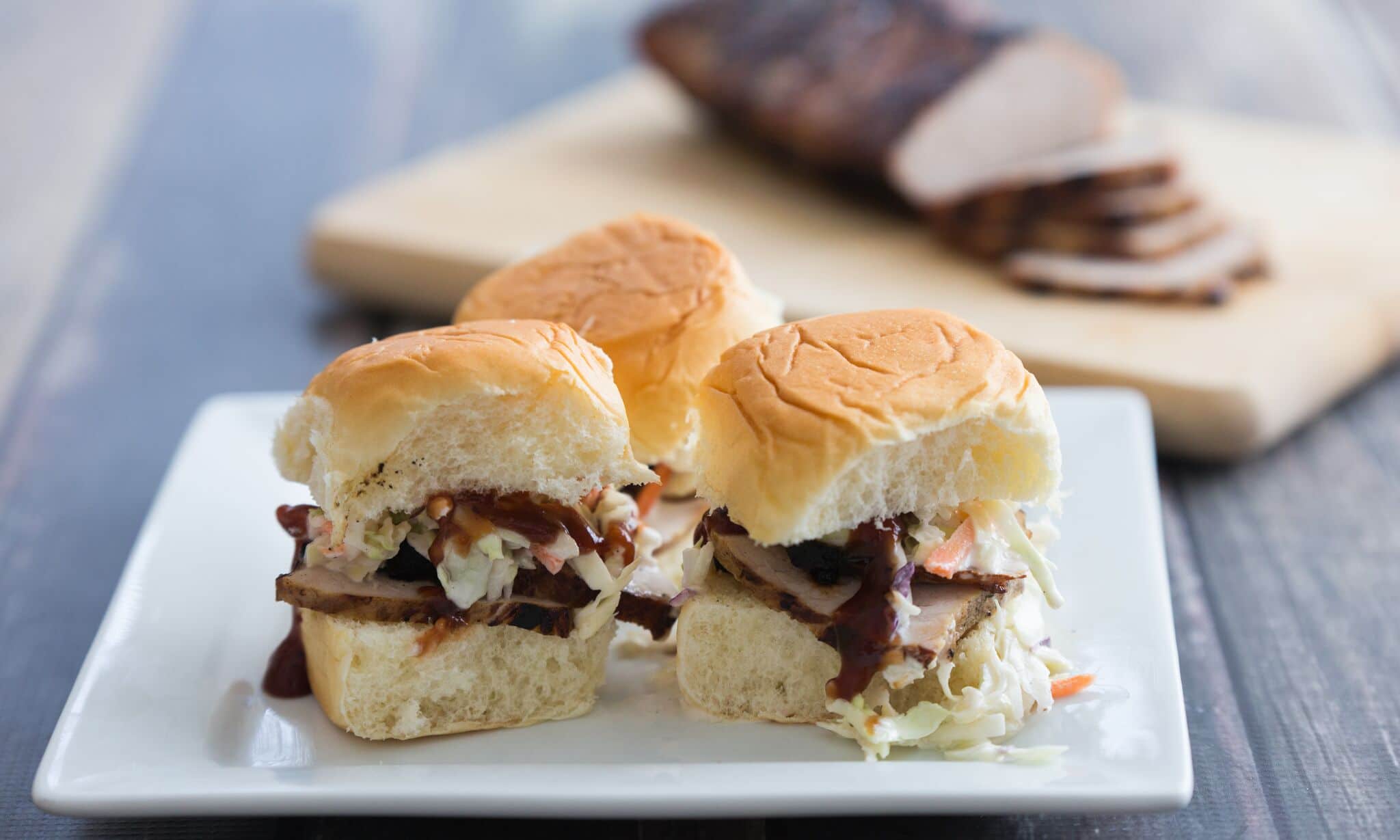 Serve pork sliders with slaw on Hawaiian rolls. 