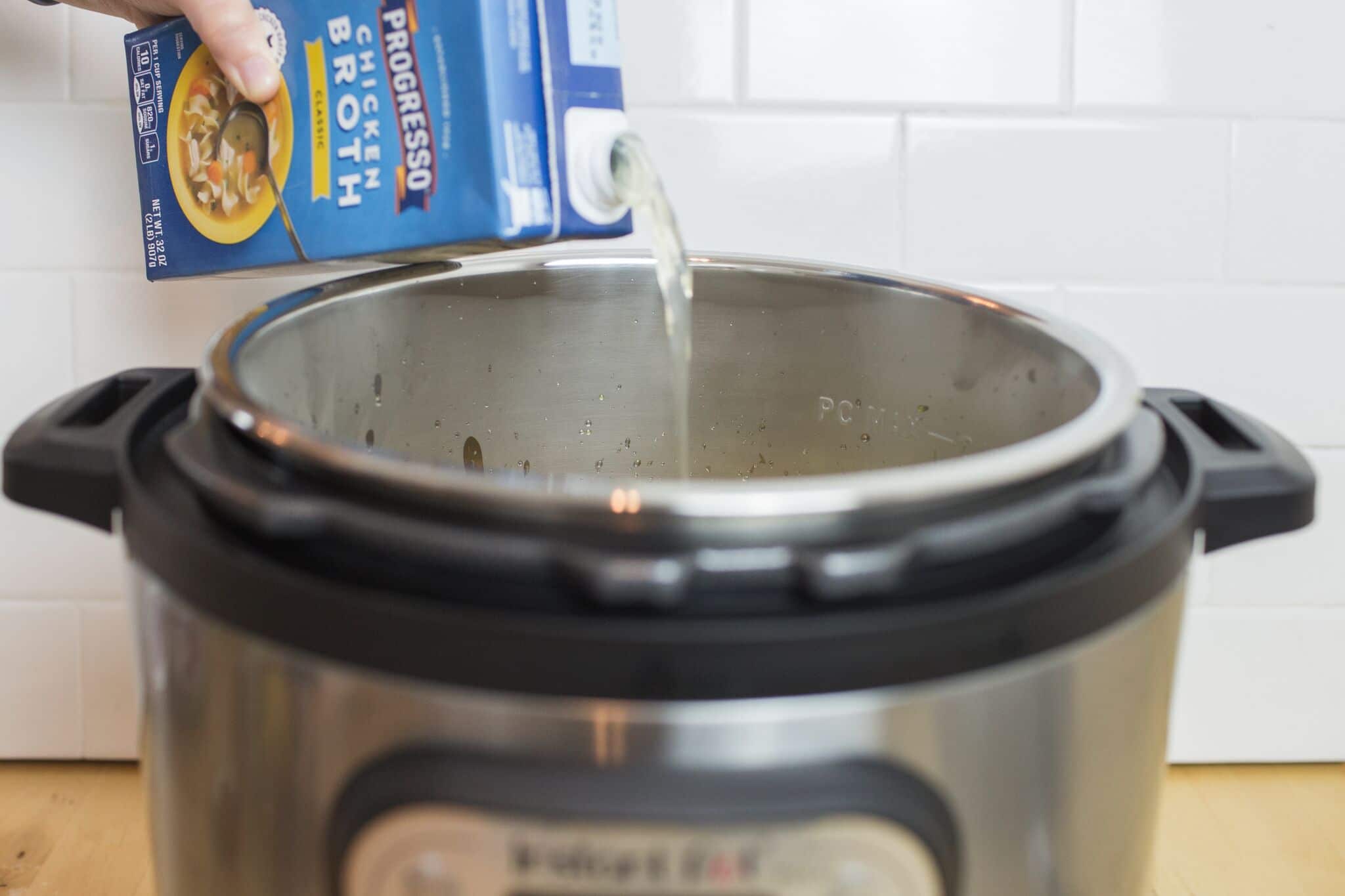 Add the carton of chicken stock to the Instant pot. 