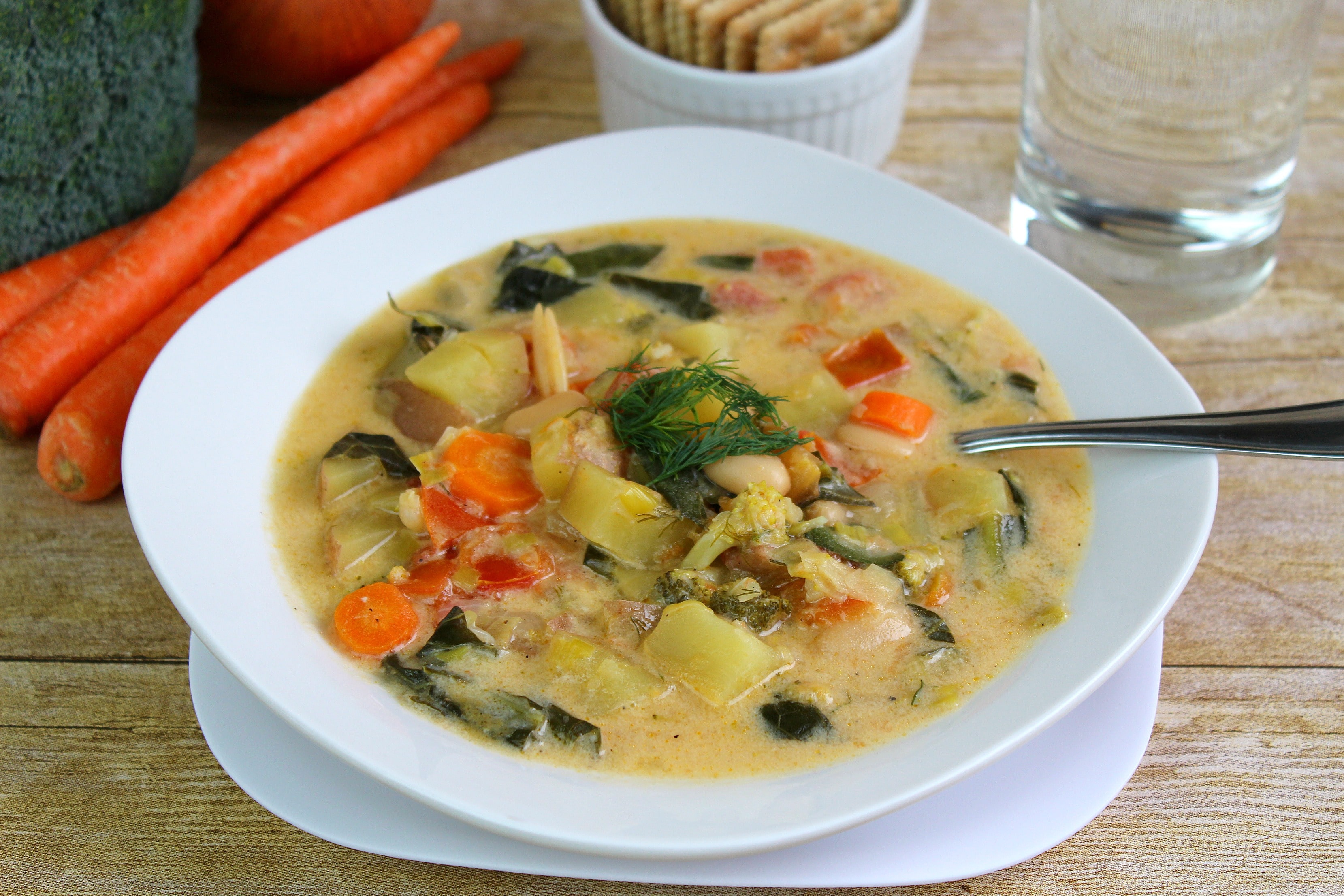 Serve the finished creamy dill vegetable soup with crackers and a fresh garnish. 