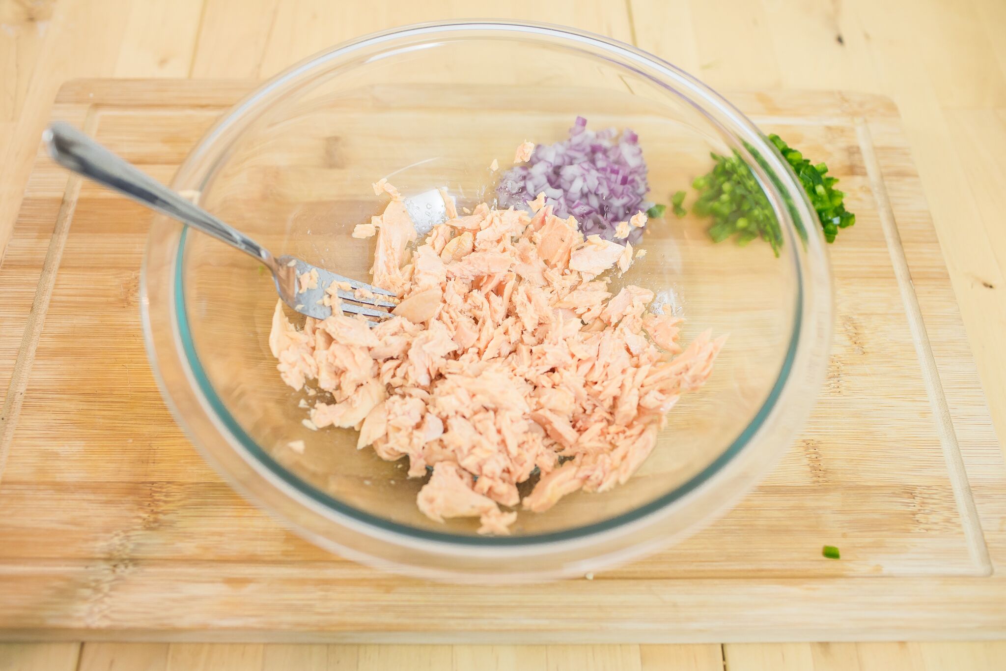 In a large bowl, break up smoked salmon with a fork.