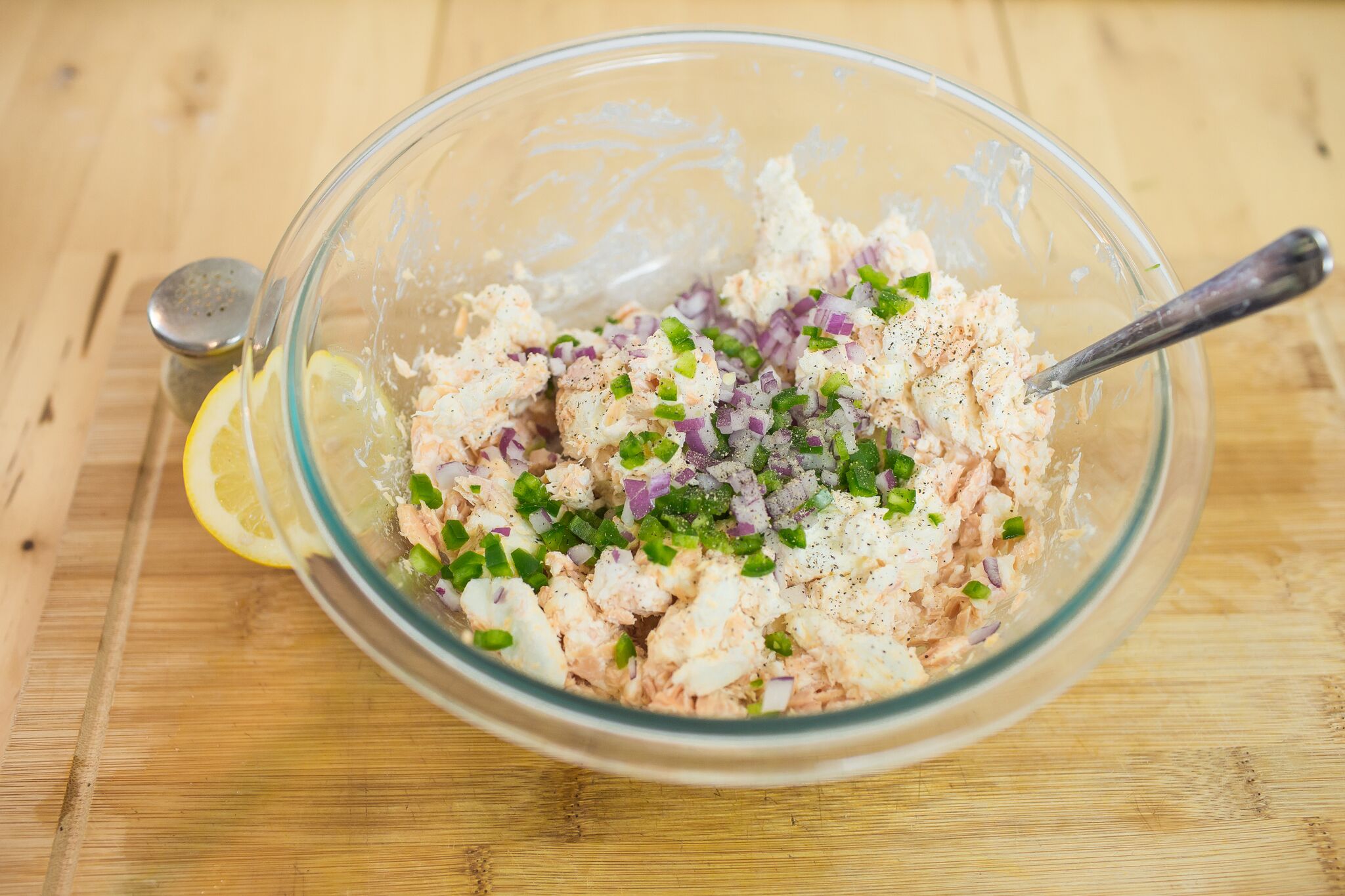Add softened cream cheese, chopped jalapeno, red onion, lemon juice and pepper to salmon in the bowl and mix. 