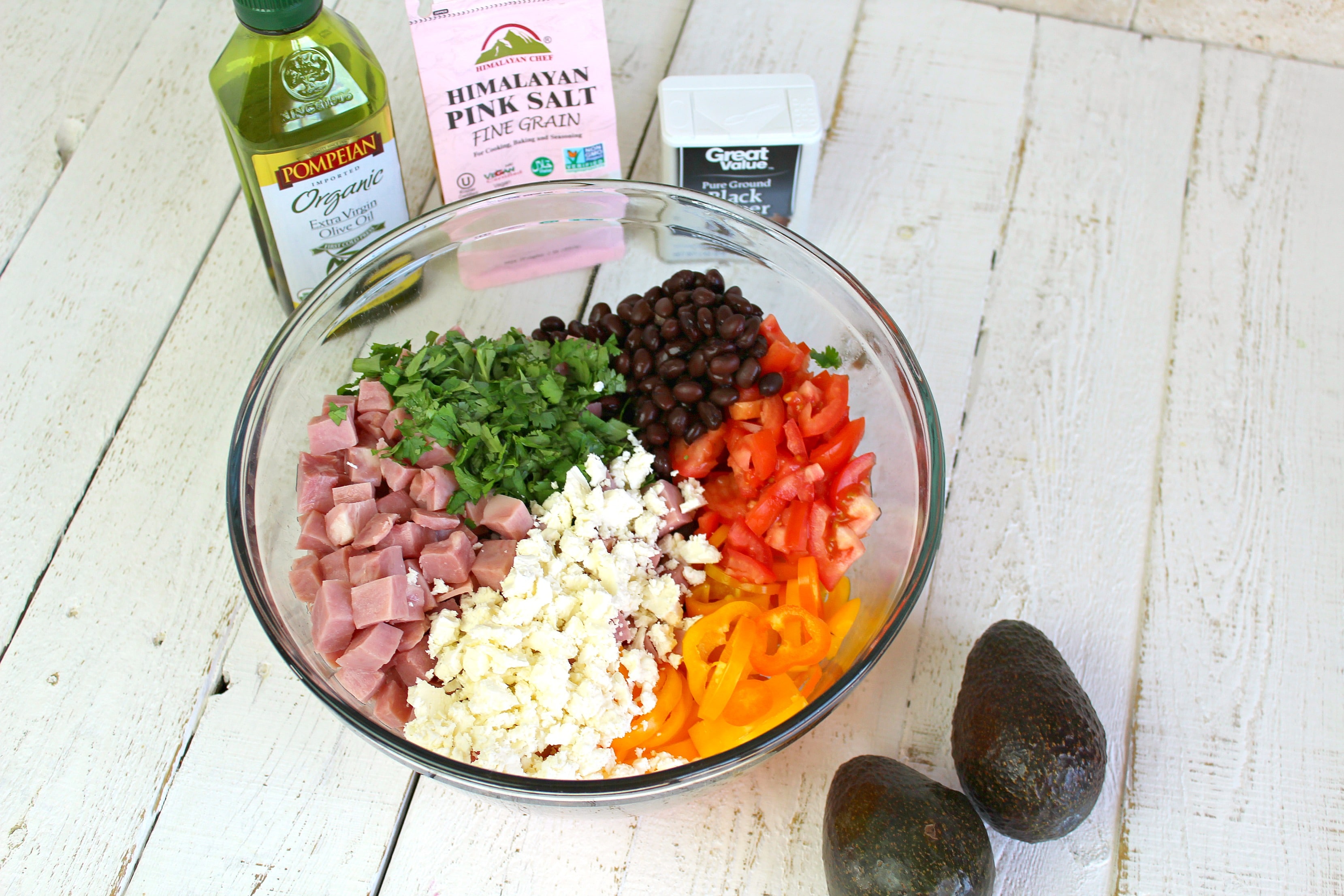 In a large bowl, add chopped veggies, black beans, crumbled feta, diced ham, extra virgin olive oil, salt, and pepper.