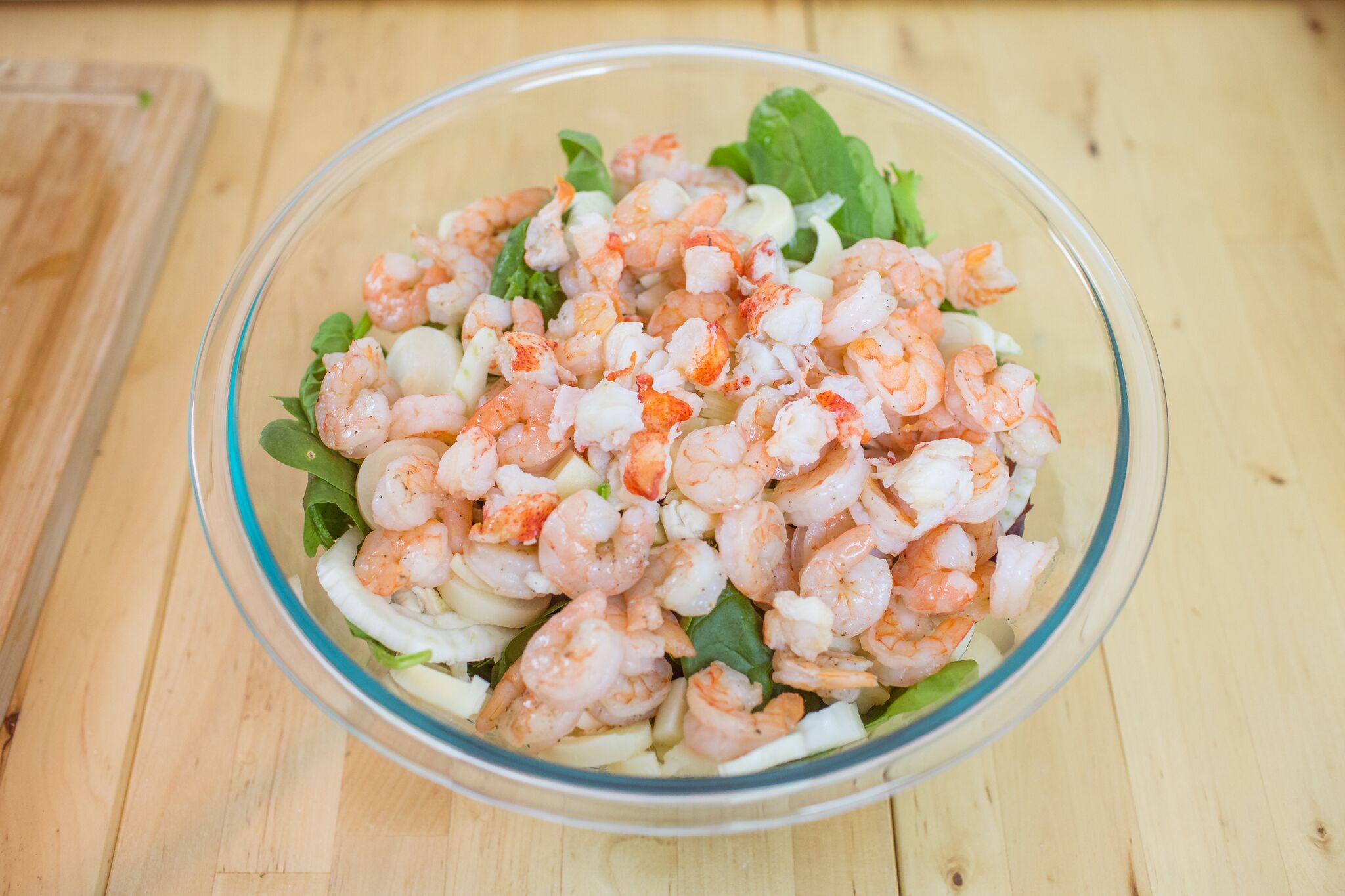 In a large bowl mix together, salad greens, sliced fennel, shrimp, lobster and add salad dressing. 