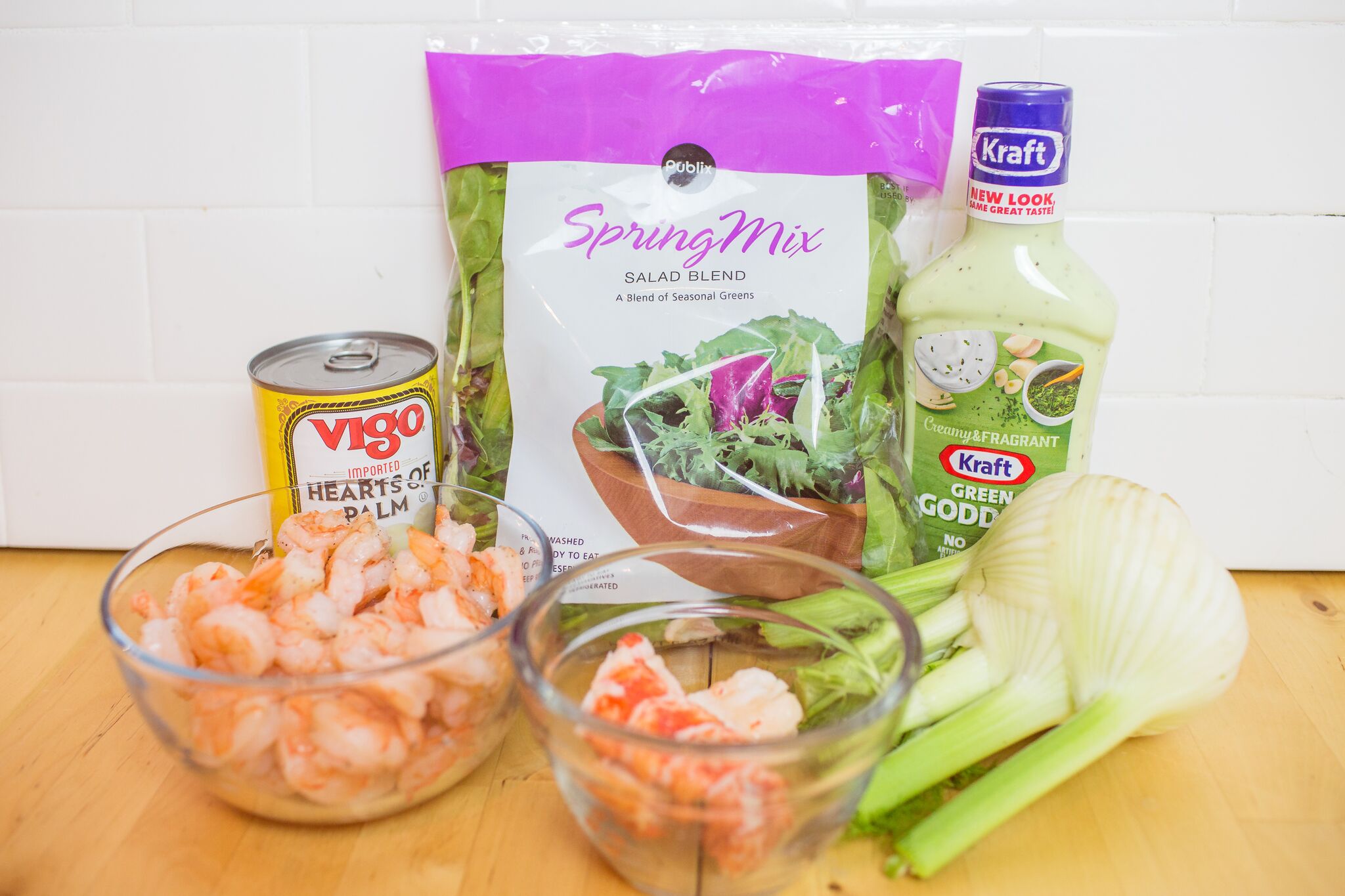 Assemble you fish salad ingredients: washed salad greens, fennel, hearts of palm, cooked shrimp, lobster tail and Green Goddess salad dressing. 