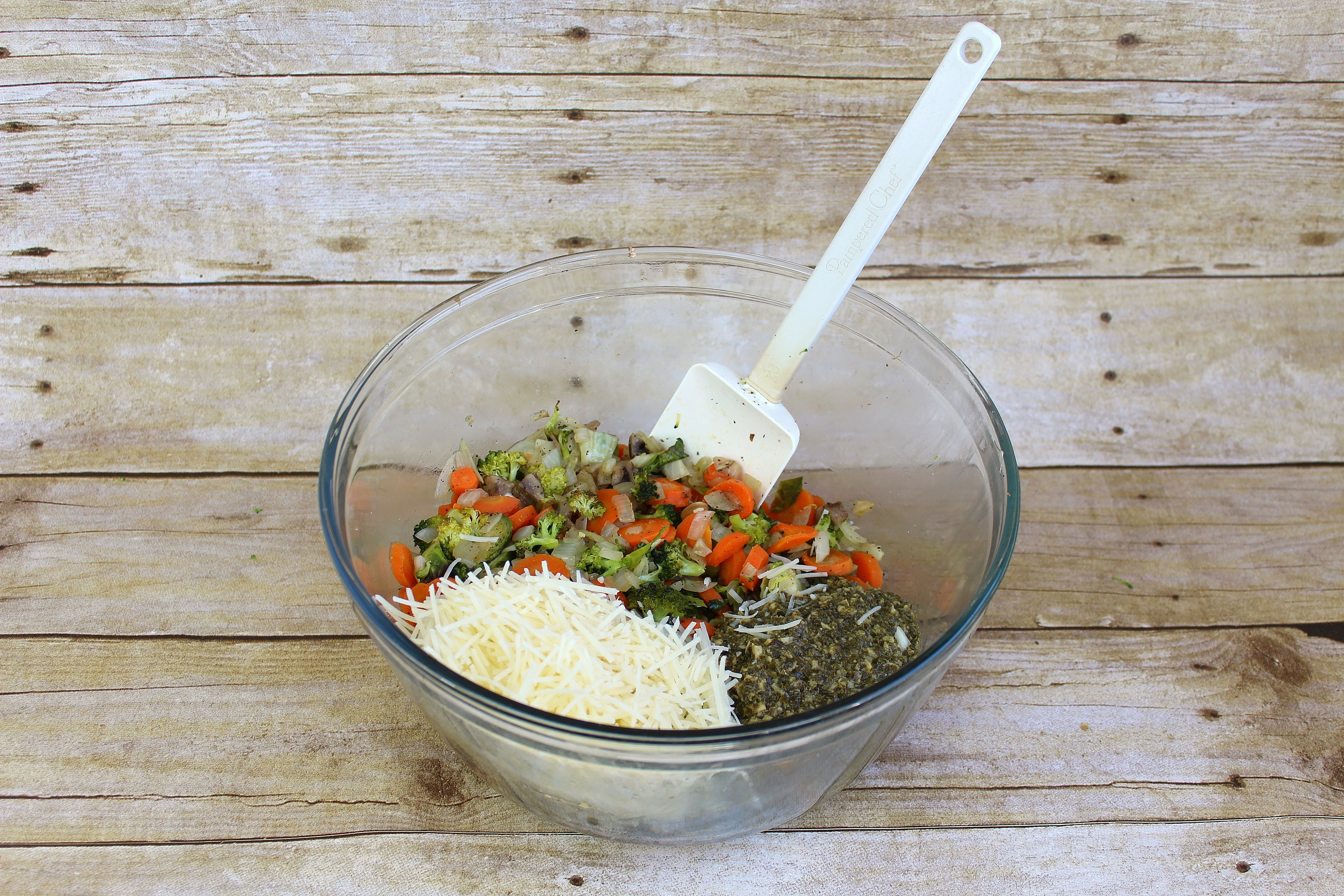 Add pesto and parmesan cheese into the roasted veggie mixture