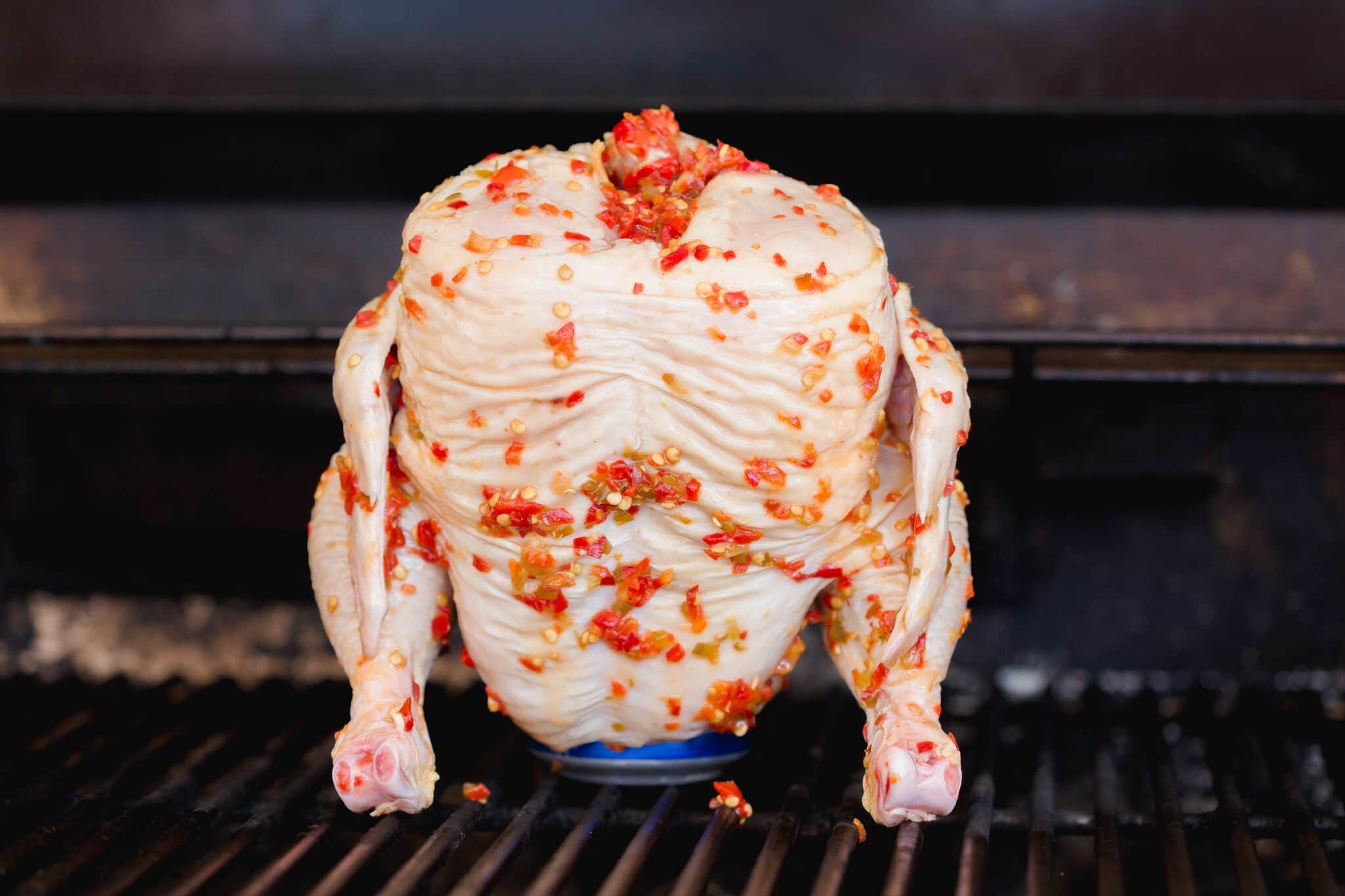 Place the beer can inside the cavity of the chicken, then grill