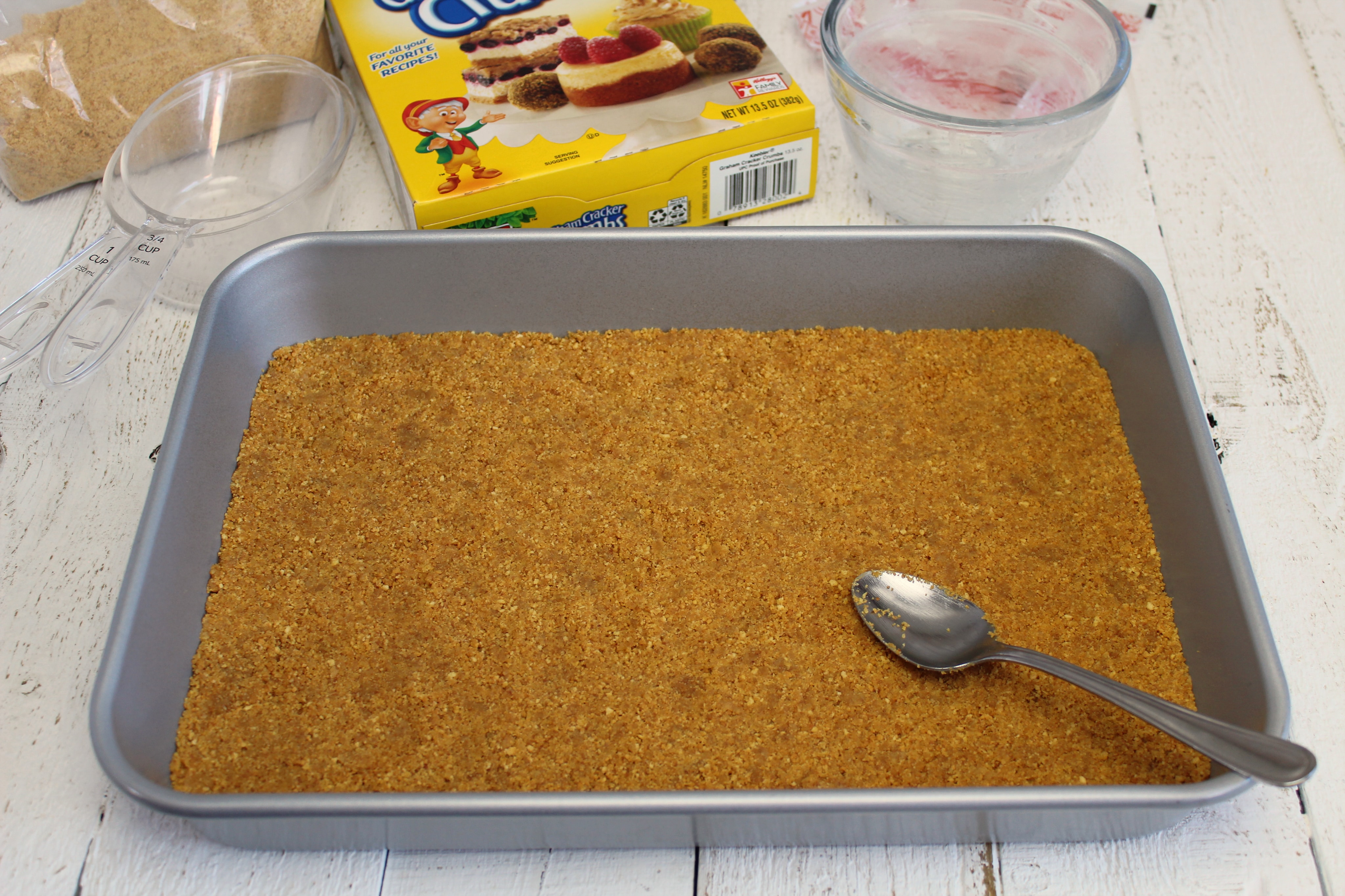 Spread graham cracker crumbs evenly on bottom of pan using a spoon. 