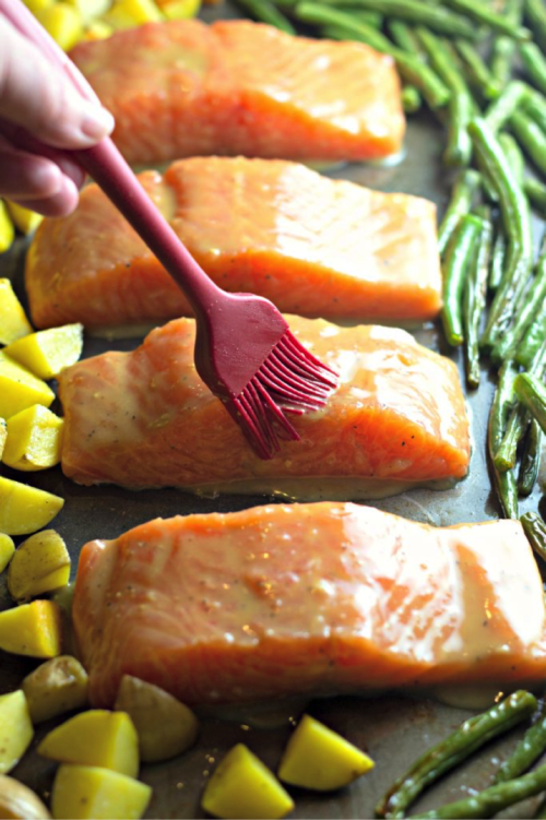 Brush salmon with Maple syrup and dijion mixture. Looking for a quick dinner recipe that uses just 5 ingredients? This Maple Glazed Sheet Pan Salmon with Potatoes and Green Beans is so easy and delicious! #recipes #easyrecipes #seafoodrecipes #onepanrecipes #5ingredientrecipes